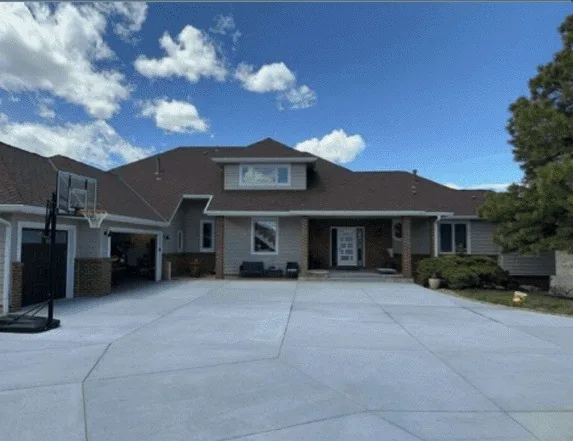 Two-storey home with a hip roof and attached garage under a clear blue sky